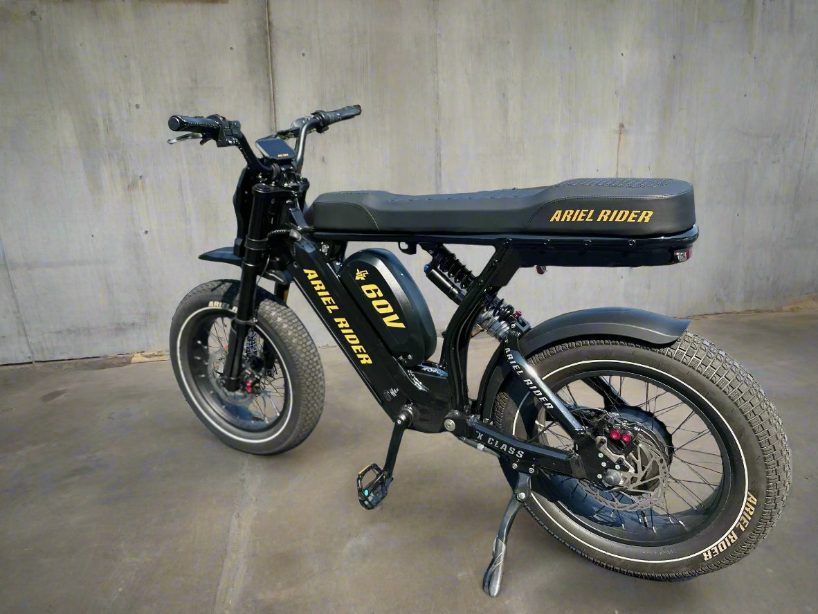 Black electric bike with 'Ariel Rider' branding on a paved surface.