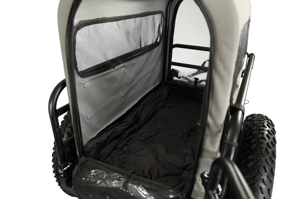 Interior view of Ariel Rider dog carrier trailer with padded floor and mesh sides.